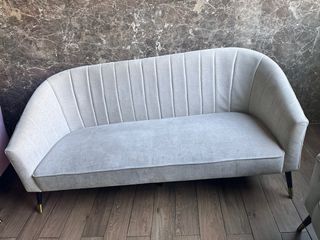 Sofá de tela gris con patas doradas