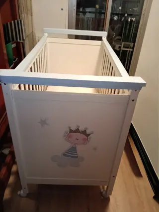 Cuna de bebé blanca con detalles azules