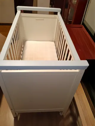 Cuna de bebé blanca con detalles azules