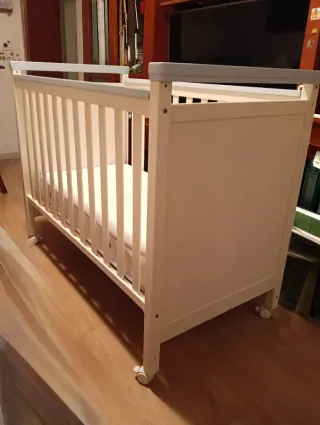 Cuna de bebé blanca con detalles azules