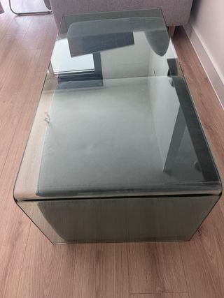 Tavolo in cristallo con 2 pouf grigi. Marca Natuzzi