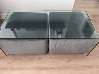 Tavolo in cristallo con 2 pouf grigi. Marca Natuzzi