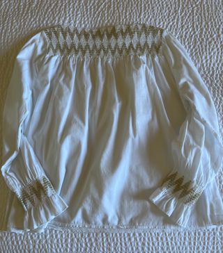 Blusa blanca con frunces dorados