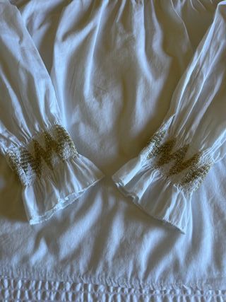Blusa blanca con frunces dorados