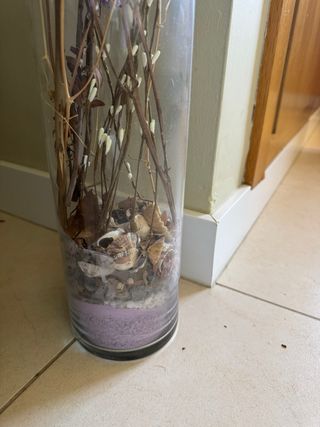 Jarrón de cristal con piedras y flores secas