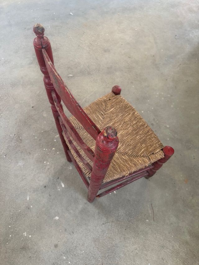 Silla antigua de madera y mimbre roja