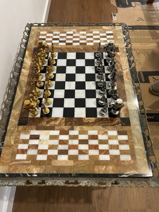 Tablero de ajedrez de mármol y figuras metálicas