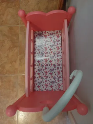 Cuna de muñecos rosa con móvil