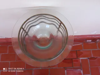 Macetero de pie metálico con plato de cristal.