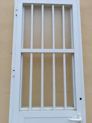 Puerta aluminio blanca con rejas