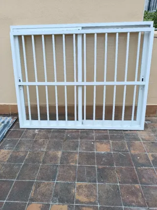 Puerta aluminio blanca con rejas