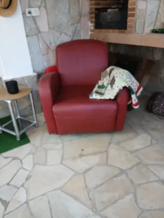 Sillón de piel rojo con manta