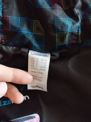 Abrigo acolchado negro con cremalleras azules