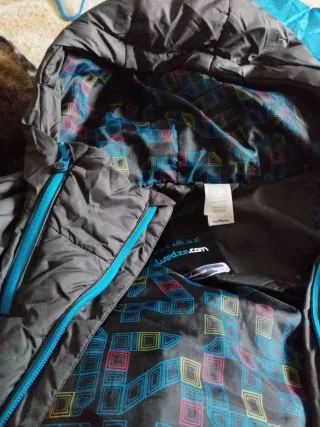 Abrigo acolchado negro con cremalleras azules