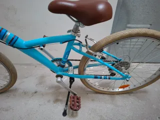 Bicicleta azul infantil con sillín marrón