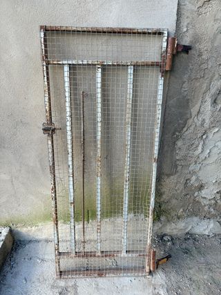 Puerta metálica con pestillo y garras.