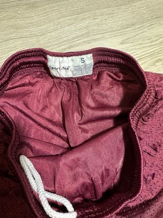 Shorts deportivos morados con logo dorado