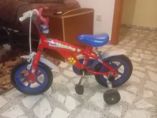 Bicicleta infantil roja con ruedines