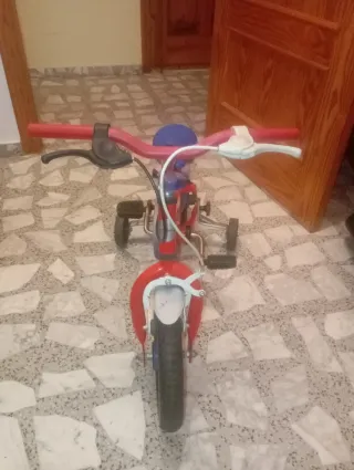 Bicicleta infantil roja con ruedines