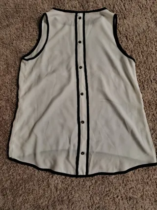 Camisa blanca plisada Camisa sin manga