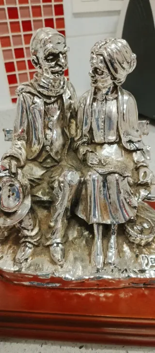 Figura de plata de abuelos sentados