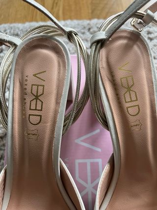 Zapatos de tacón blancos y dorados