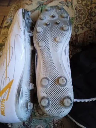 Zapatillas de fútbol blancas y doradas