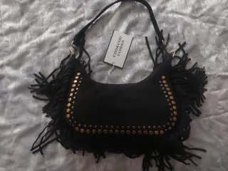 Borsa nera con borchie dorate e frange