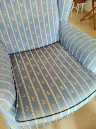 Sillón orejero azul con estampado floral