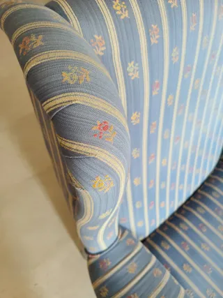 Sillón orejero azul con estampado floral