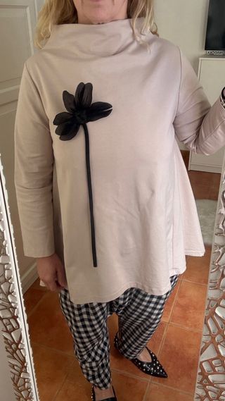 Casaca cuello chimenea beige con flor negra