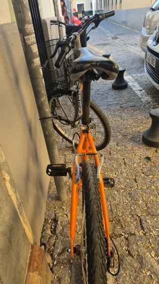 Bicicleta de montaña naranja con cesta
