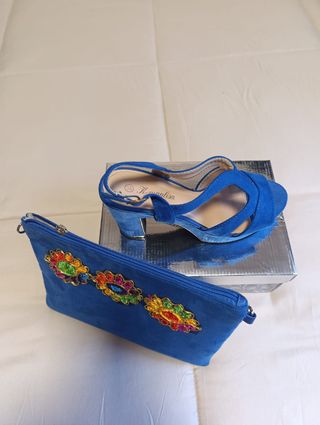 Zapatos de tacón azul a juego con la cartera.