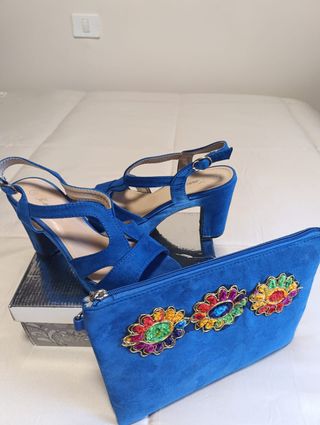 Zapatos de tacón azul a juego con la cartera.