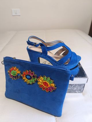 Zapatos de tacón azul a juego con la cartera.