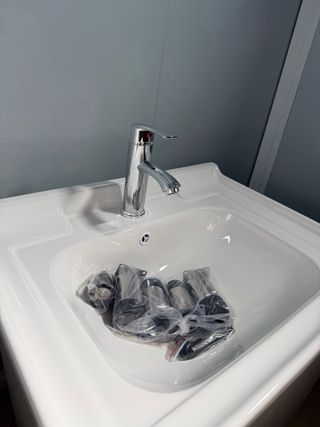 Mueble de baño con lavabo y grifo nuevos.