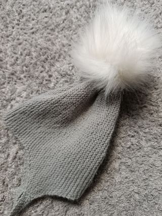 Conjunto bebé rebeca y capota gris con pompón.