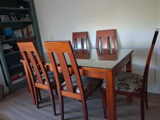 Mesa de comedor con cristal y 6 sillas de madera.