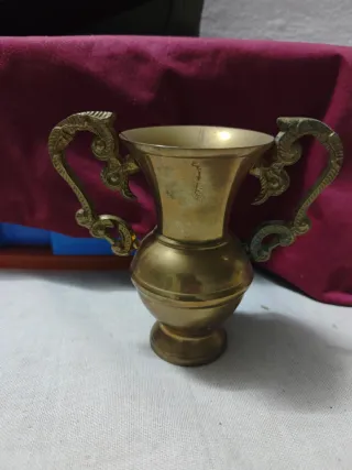 Adorno de metal dorado con asas
