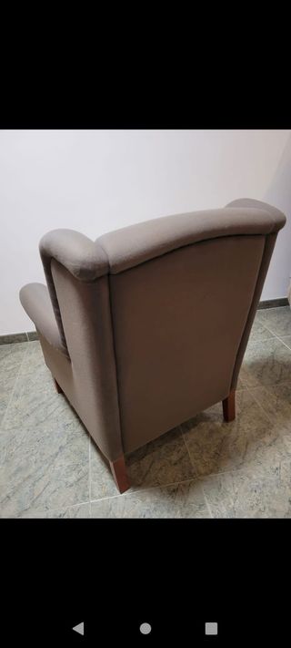 Sillón de tela gris con cojín blanco