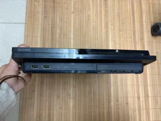 PlayStation 3 con mando, juegos y cables.