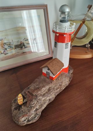 Faro decorativo su legno di mare