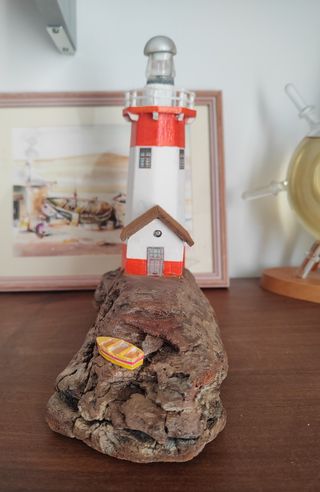 Faro decorativo su legno di mare