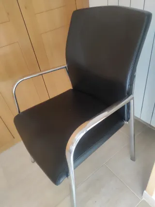 Silla de cuero negra con patas plateadas