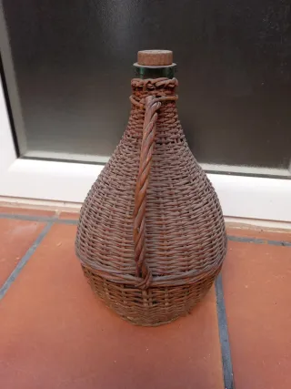 Botella antigua de vidrio con asa y cesta