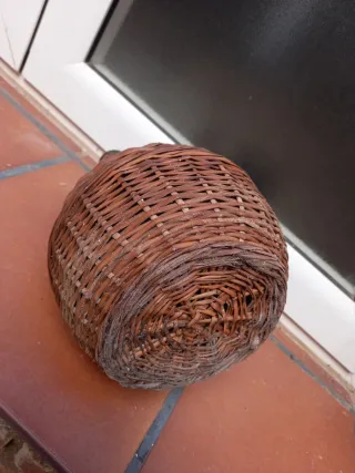 Botella antigua de vidrio con asa y cesta