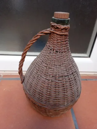 Botella antigua de vidrio con asa y cesta
