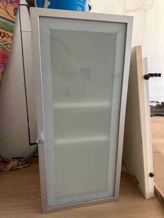 Mueble de baño plateado con puerta de cristal