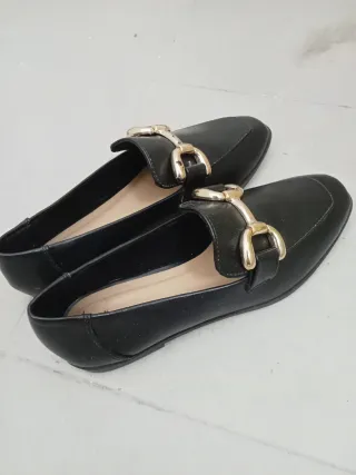 Mocasines negros con detalle de hebilla dorada