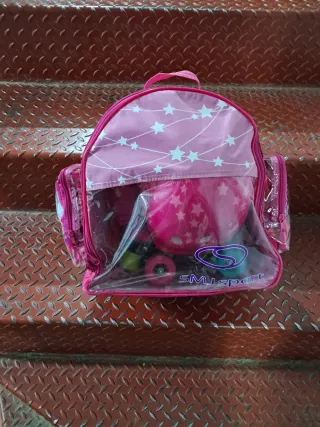Patines rosas con protecciones, mochila y casco